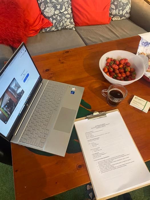 Laptop, dokumenty, kawa i miska owoców podczas Walnego Zebrania Kooperatywy Naturalnie